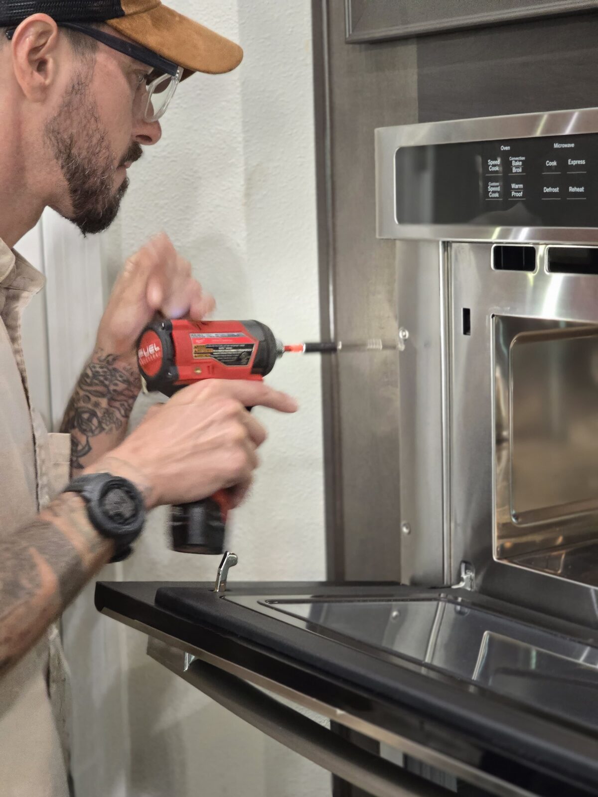 Sam Barmichev of Lexington Appliance Repair servicing a built-in oven