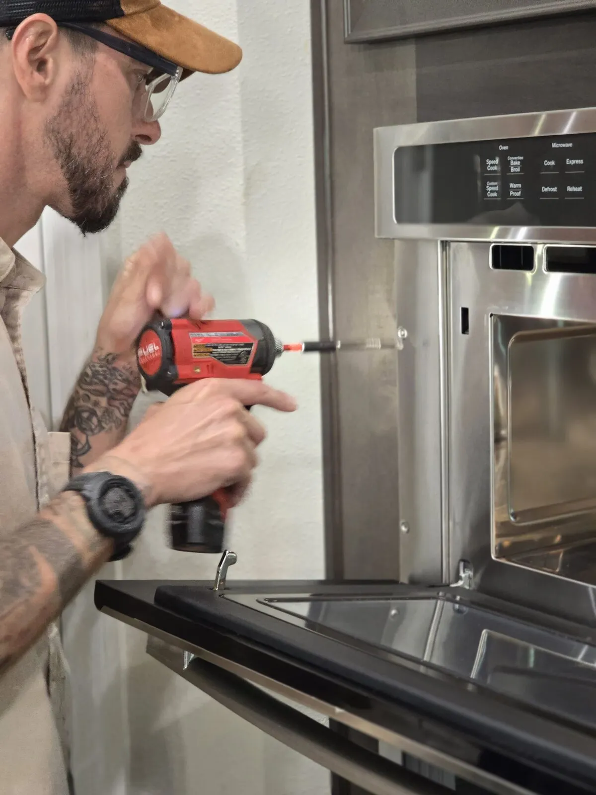 Sam Barmichev of Lexington Appliance Repair servicing a built-in oven
